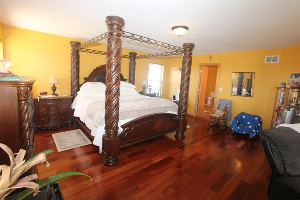 a bedroom with a bed dresser and a window