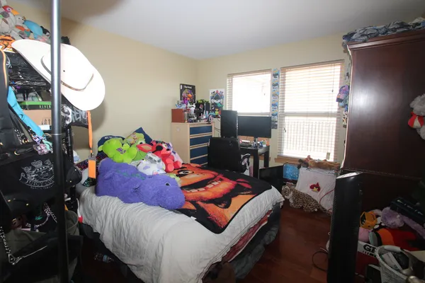 a bedroom with a bed a window and dresser