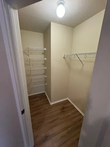 a view of walk in closet with wooden floor