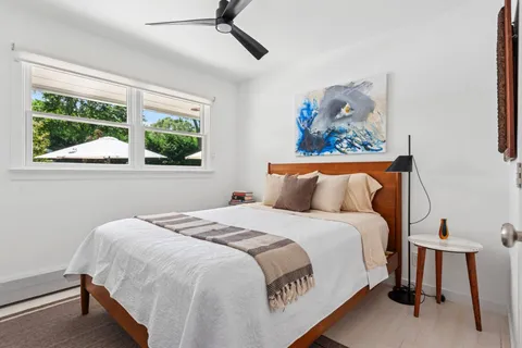 a bedroom with a bed and a painting on the wall