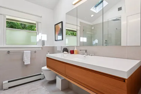 a bathroom with a sink a toilet and a mirror