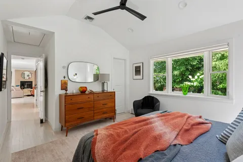 a bedroom with a bed window and dresser