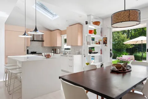 a kitchen with a table chairs and a living room