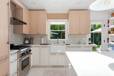 a kitchen with a sink a stove and cabinets