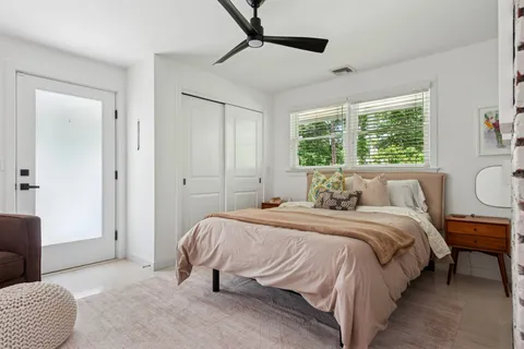 a bedroom with a bed a couch and a window