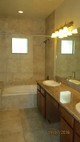 a bathroom with a granite countertop sink a toilet and bathtub