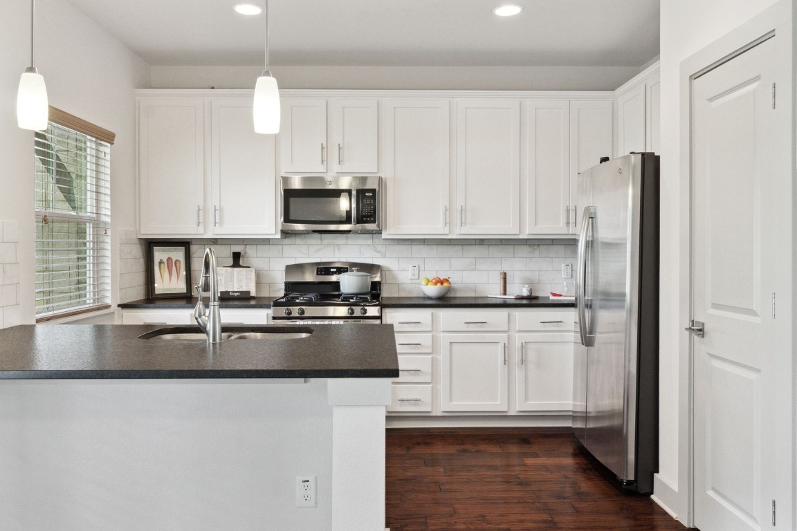 Pristine white cabinetry and granite counters adorn the kitchen.