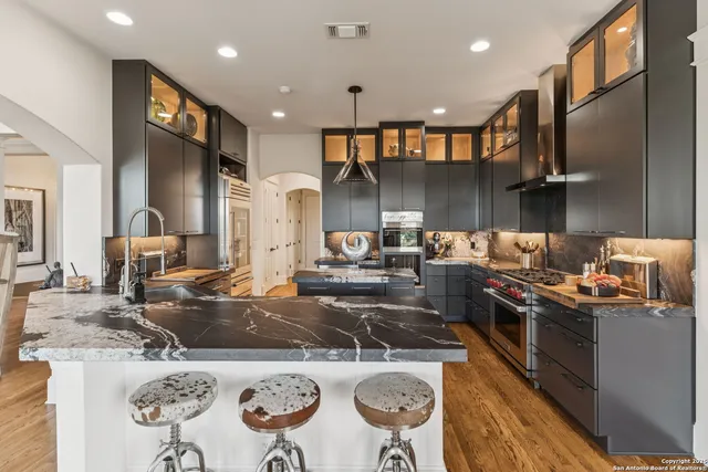 a kitchen with stainless steel appliances granite countertop a stove a sink and a refrigerator
