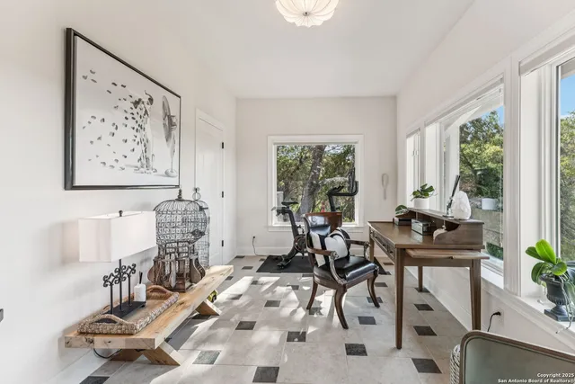 a room with pool table kitchen view and windows
