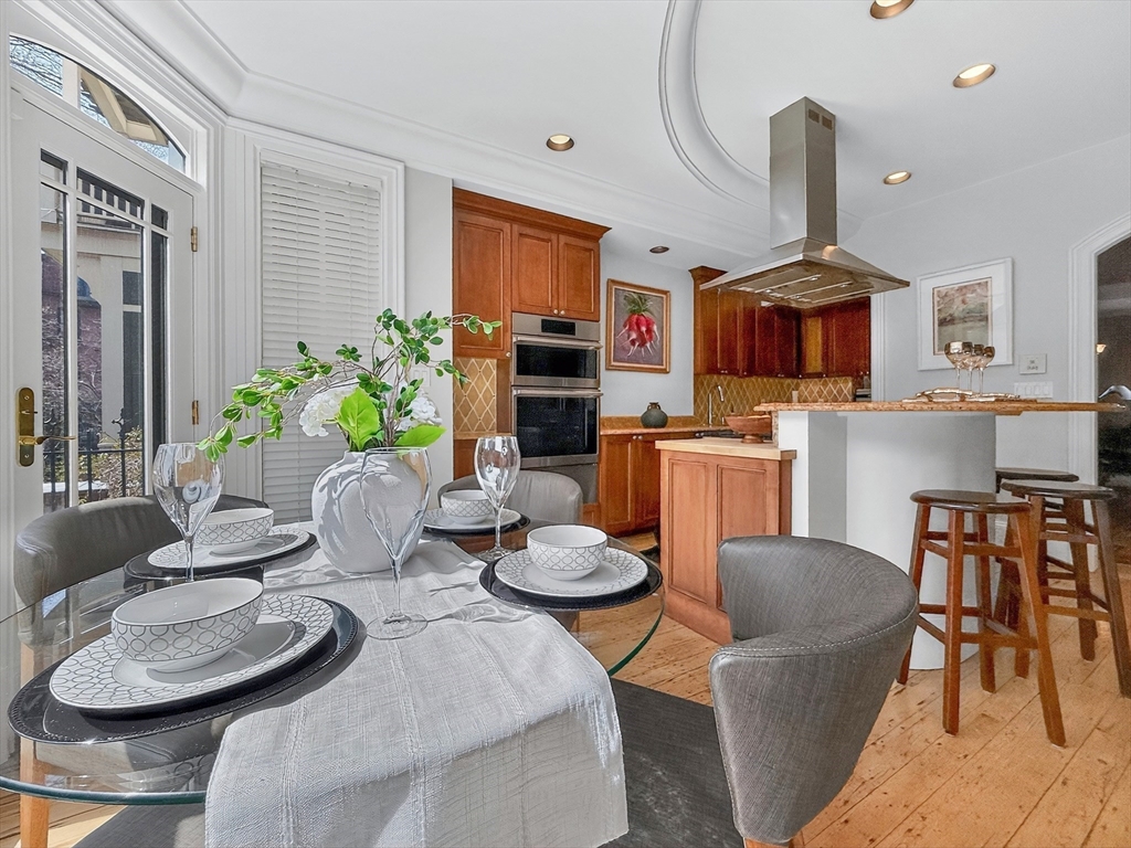 70 Montgomery Street Boston, MA 02116 - Photo 15 of 42 a kitchen with stainless steel appliances kitchen island granite countertop a dining table and chairs