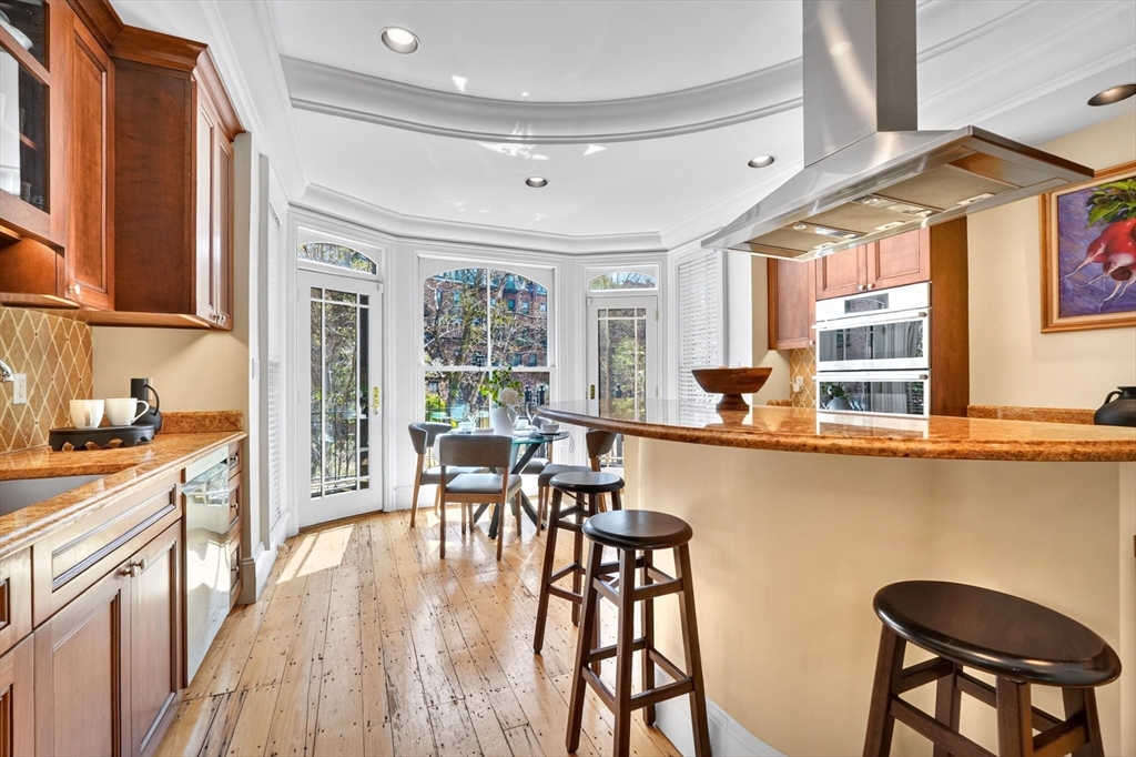 70 Montgomery Street Boston, MA 02116 - Photo 10 of 42 a kitchen with a table chairs stove and cabinets