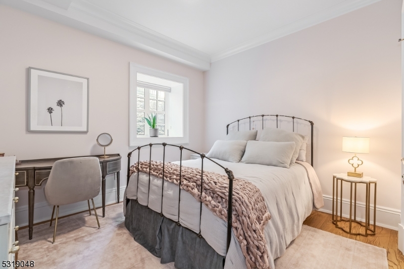 80 Claremont Road, Unit 802 Bernardsville, NJ 07924 - Photo 14 of 22 a bedroom with a bed a chandelier and dresser