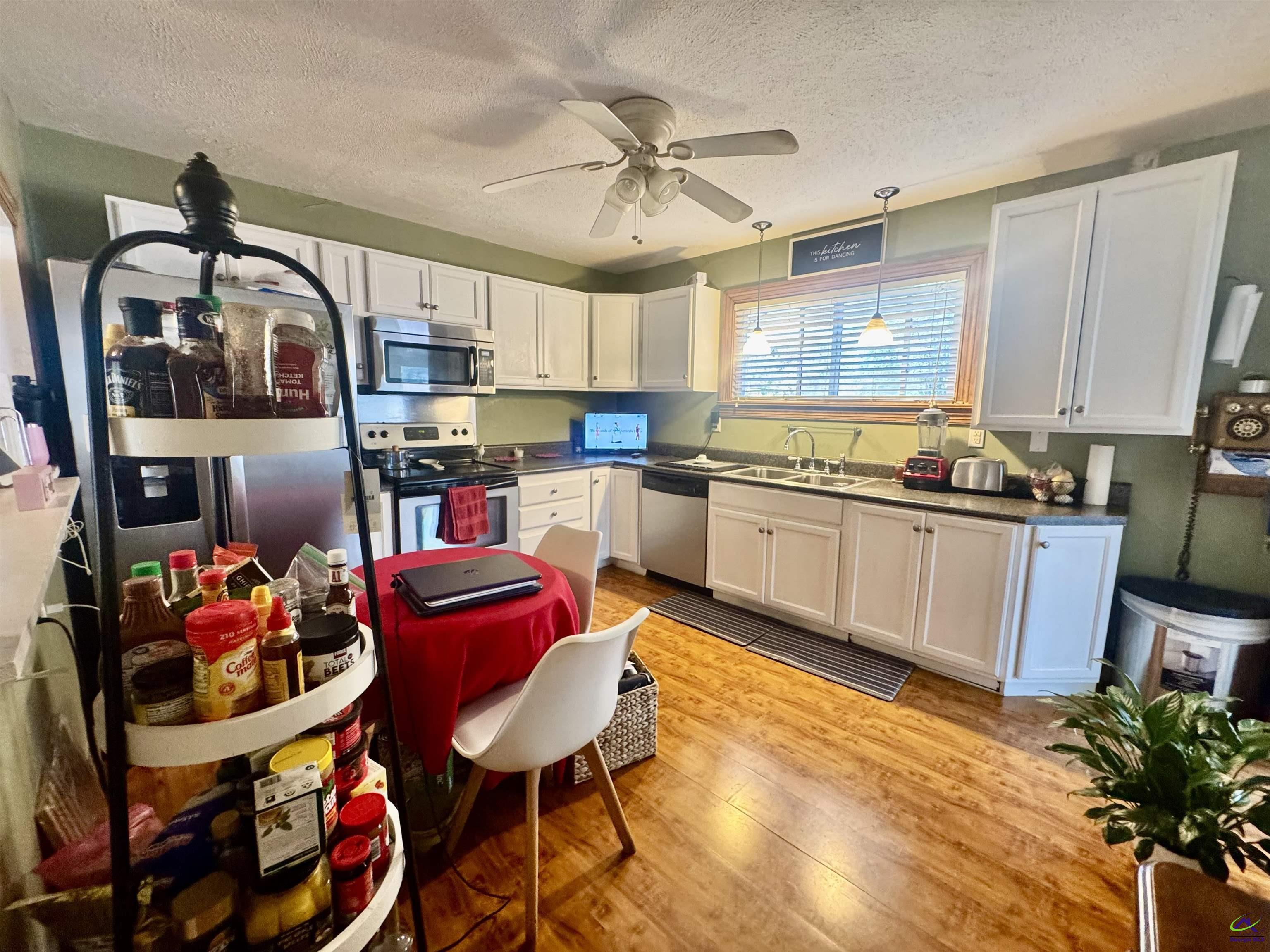 914 Adderton Street Americus, GA 31719 - Photo 36 of 53 a kitchen with stainless steel appliances granite countertop a sink dishwasher and a dining table with cabinets