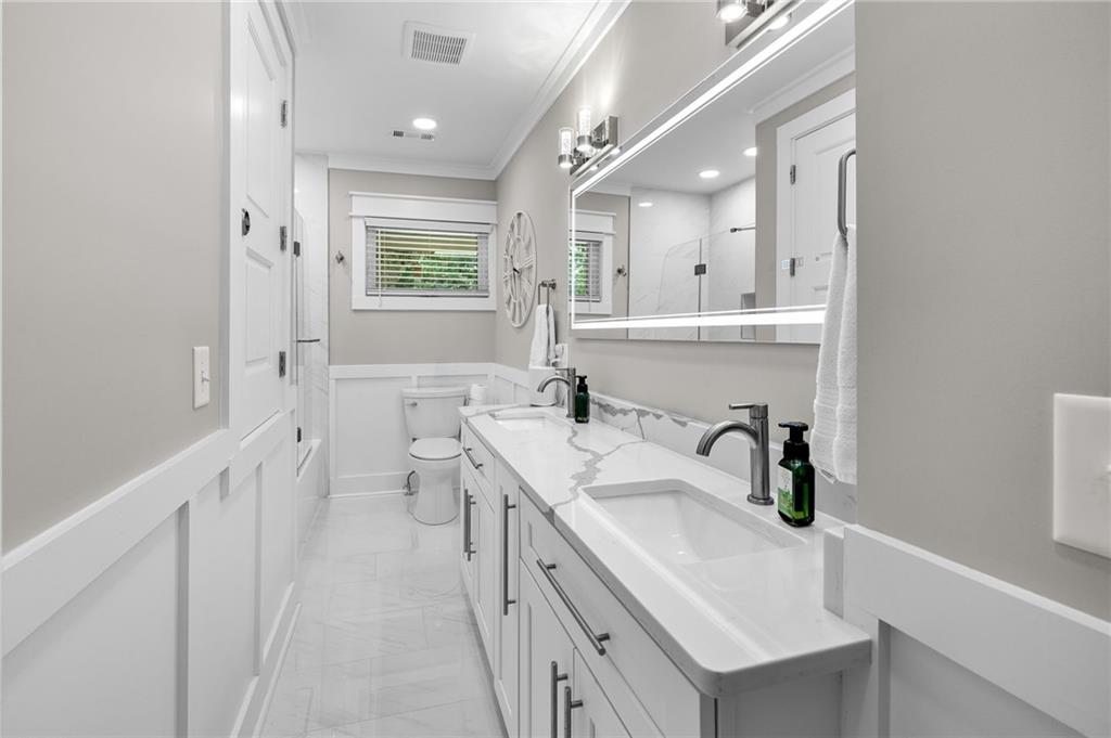 6470 Samoa Way Flowery Branch, GA 30542 - Photo 45 of 61 a bathroom with a sink a toilet a mirror and vanity
