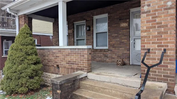 a view of a brick house with a small yard
