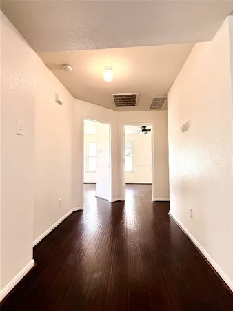 a view of a hallway with wooden floor