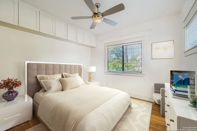 a bedroom with a bed a window and a potted plant on a dresser