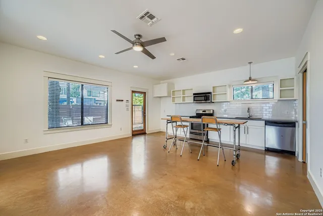 a view of a kitchen with furniture and wooden floor