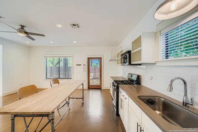 a kitchen with stainless steel appliances granite countertop a sink a stove and wooden cabinets