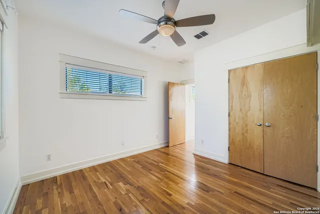 a view of an empty room with wooden floor