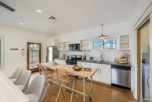 a kitchen with stainless steel appliances kitchen island granite countertop a sink and cabinets