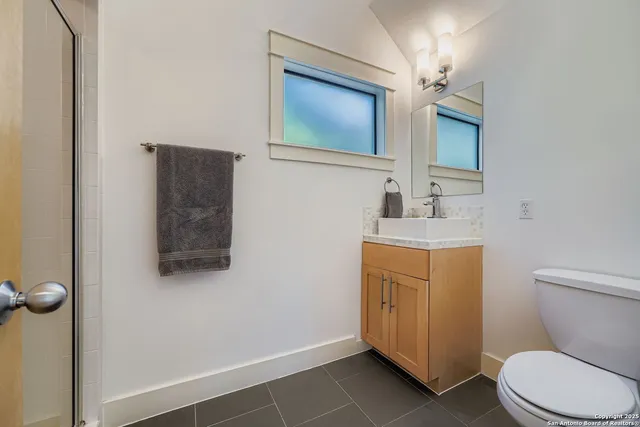 a bathroom with a toilet sink and mirror