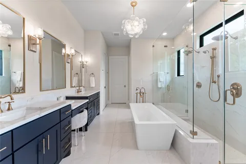 a spacious bathroom with a granite countertop tub sink shower and mirror
