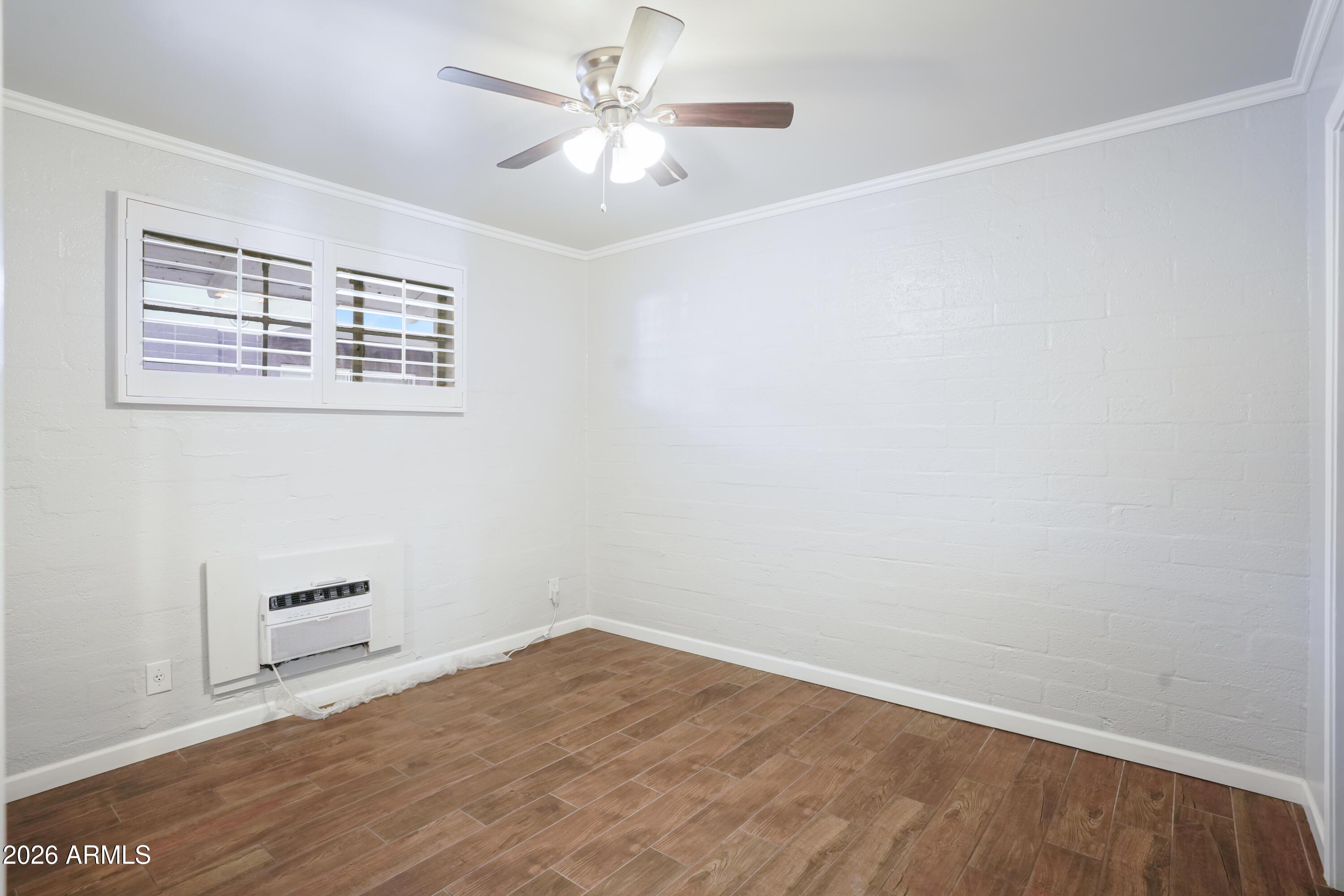 3426 North Miller Road, Unit 5 Scottsdale, AZ 85251 - Photo 11 of 11 an empty room with a ceiling fan and wooden floor