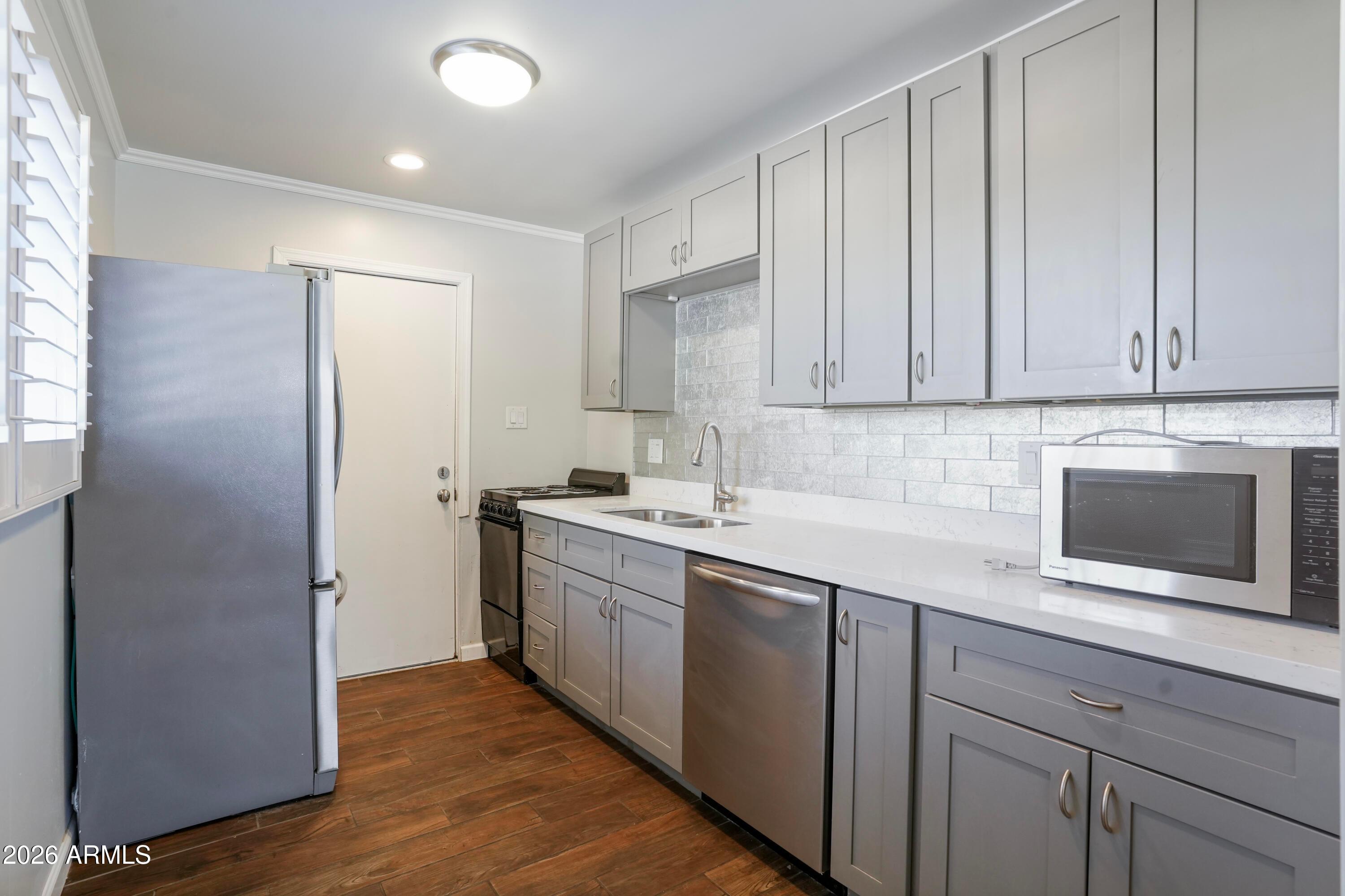 3426 North Miller Road, Unit 5 Scottsdale, AZ 85251 - Photo 2 of 11 a kitchen with stainless steel appliances granite countertop a refrigerator and a sink
