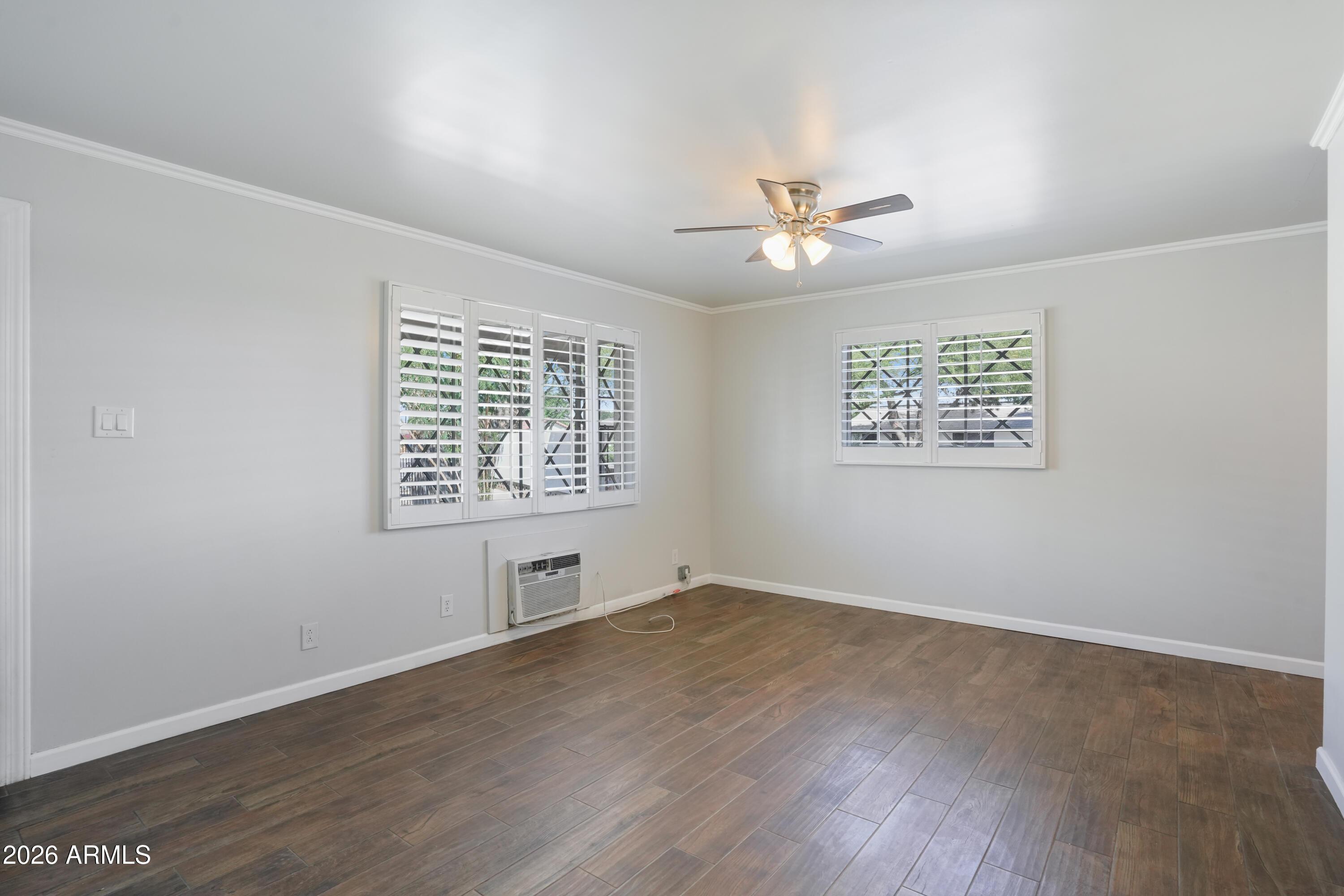 3426 North Miller Road, Unit 5 Scottsdale, AZ 85251 - Photo 8 of 11 an empty room with wooden floor ceiling fan and windows