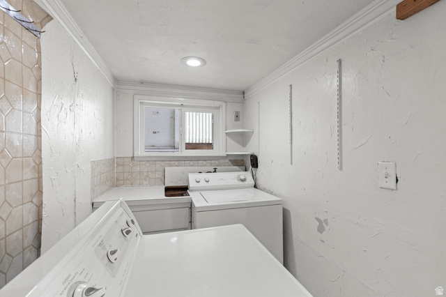 180 South 300 East Logan, UT 84321 - Photo 24 of 35 Laundry area with ornamental molding, a textured wall, and washing machine and clothes dryer
