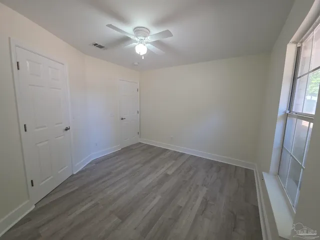 an empty room with wooden floor and window