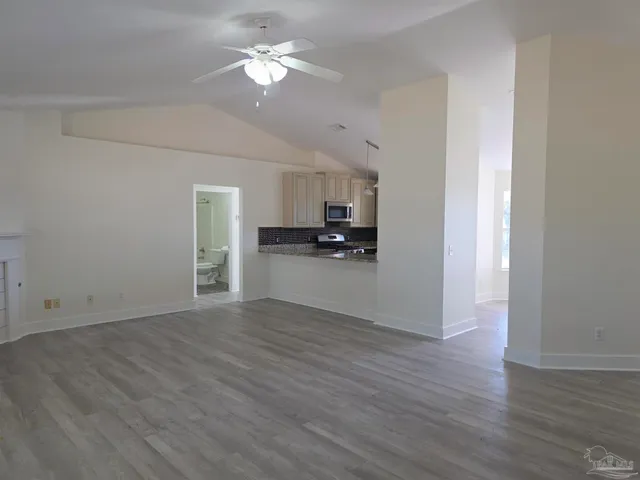 a view of a kitchen with wooden floor and a kitchen space