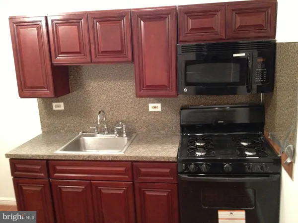 a kitchen with granite countertop a sink stainless steel appliances and cabinets