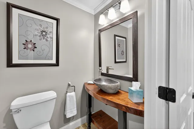 a view of a hallway to a room with wooden floor and windows