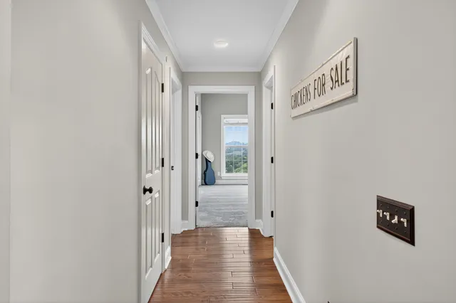 a view of a hallway with wooden floor and entryway