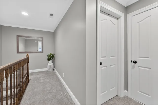 a view of a house with a big yard potted plants and a large tree