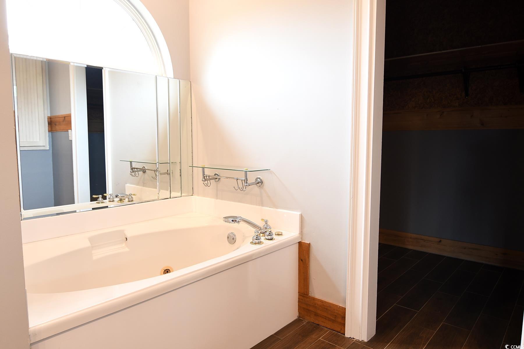 971 Folly Road Myrtle Beach, SC 29588 - Photo 16 of 25 Full bathroom with baseboards, a jetted tub, and wood finished floors