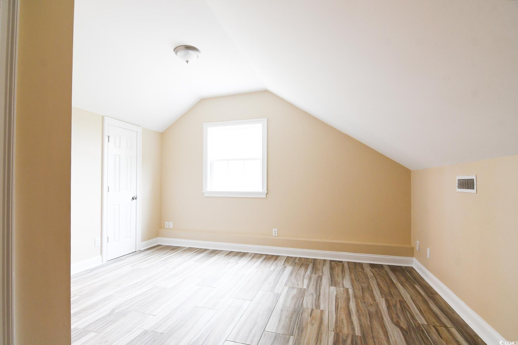 971 Folly Road Myrtle Beach, SC 29588 - Photo 19 of 25 Bonus room with light wood-style floors, visible vents, baseboards, and vaulted ceiling