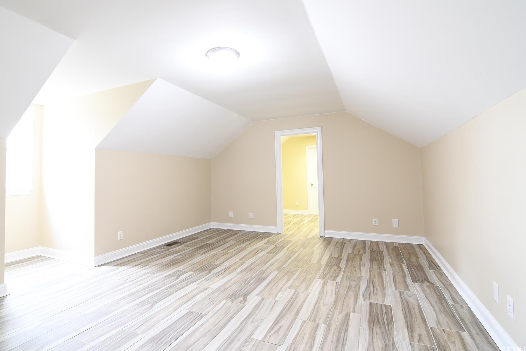 971 Folly Road Myrtle Beach, SC 29588 - Photo 20 of 25 Additional living space featuring light wood-style flooring, baseboards, and vaulted ceiling