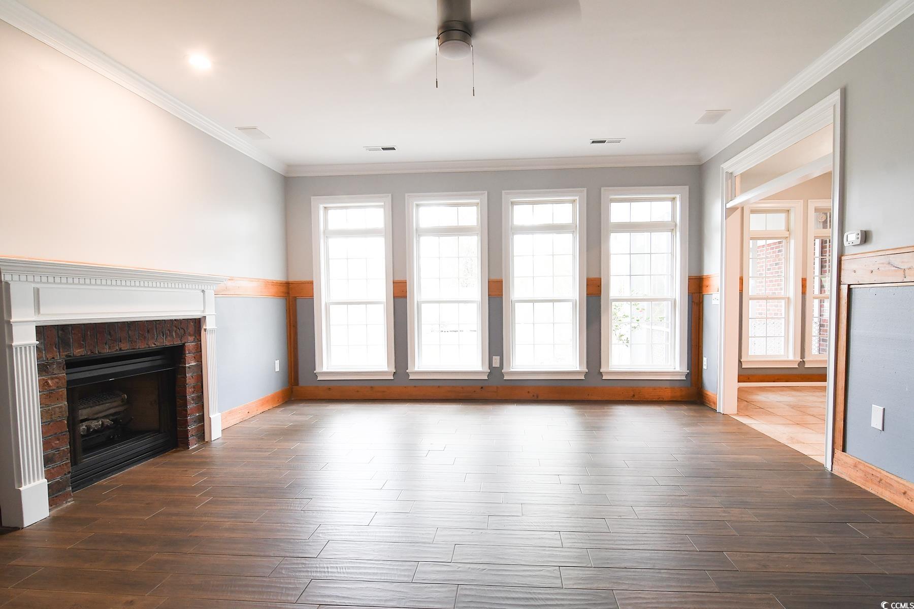 971 Folly Road Myrtle Beach, SC 29588 - Photo 2 of 25 Unfurnished living room with dark wood-type flooring, baseboards, and a ceiling fan