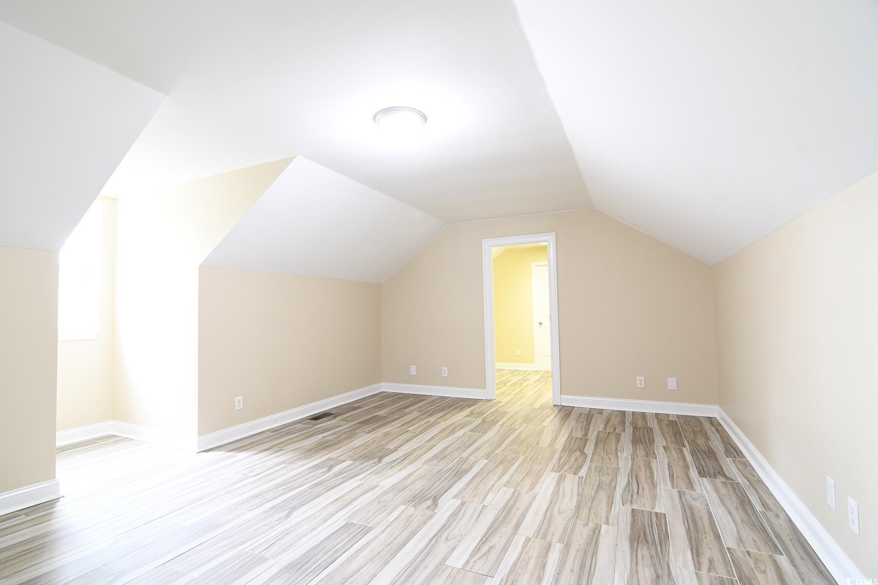 971 Folly Road Myrtle Beach, SC 29588 - Photo 21 of 25 Bonus room with light wood-style floors, baseboards, and lofted ceiling