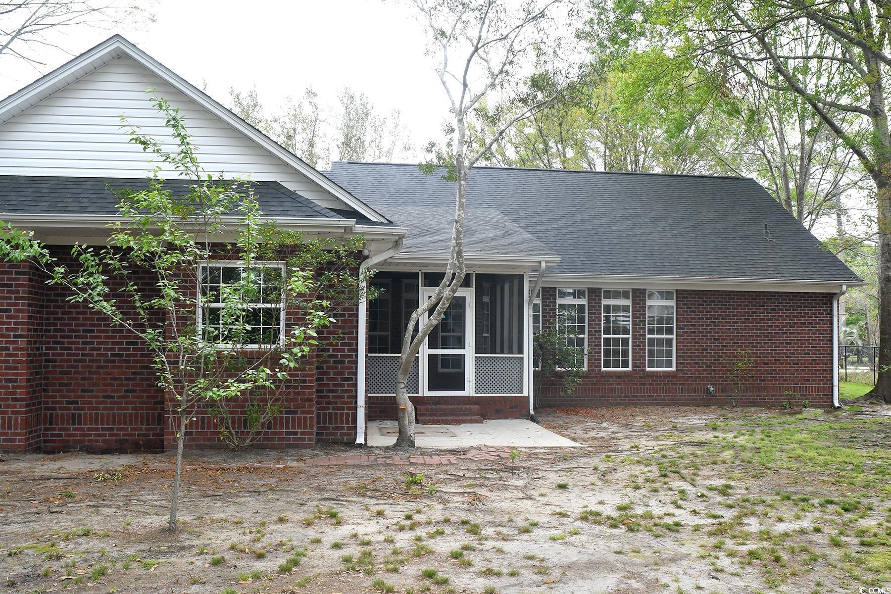 971 Folly Road Myrtle Beach, SC 29588 - Photo 22 of 25 Back of property with a sunroom, roof with shingles, and brick siding