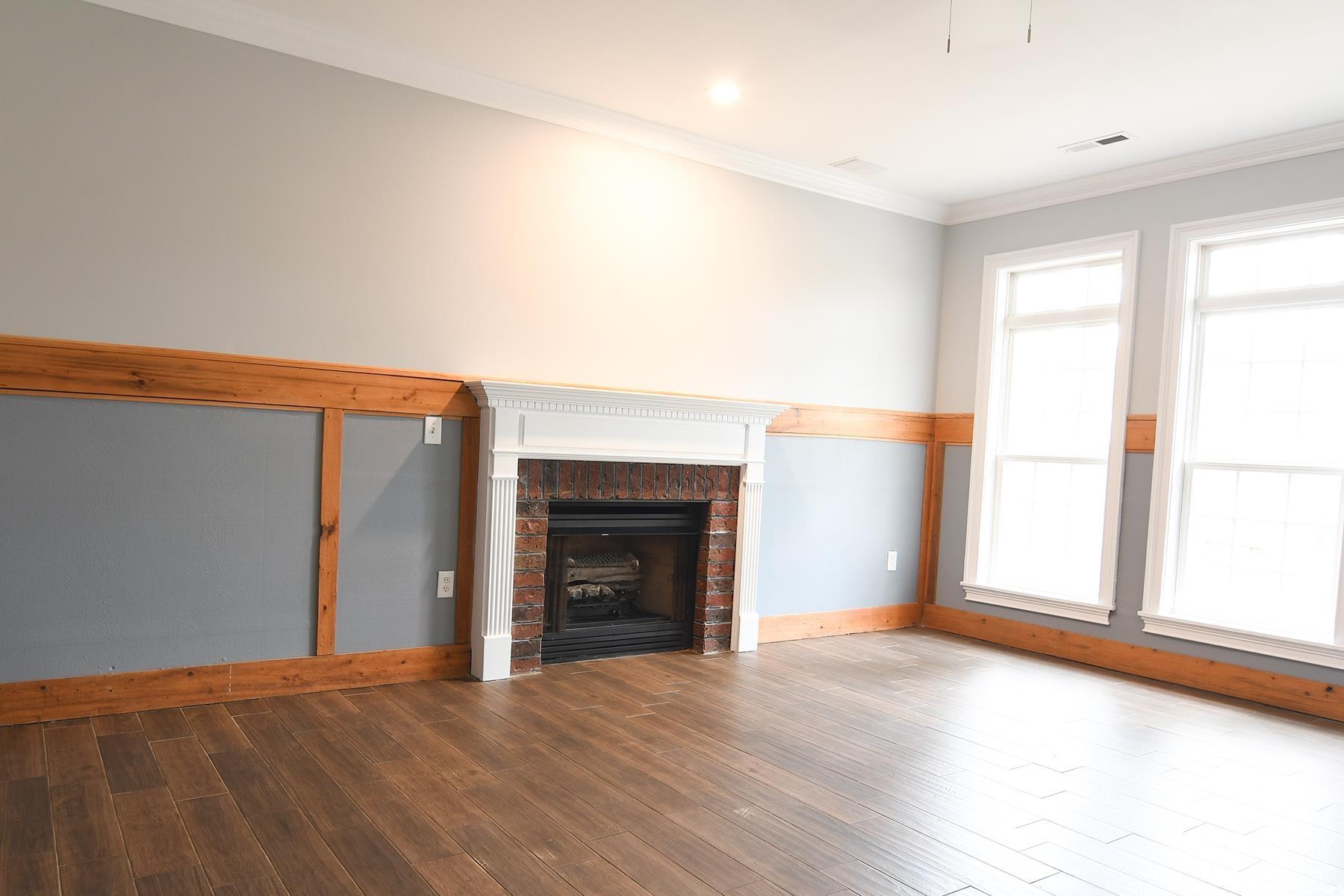 971 Folly Road Myrtle Beach, SC 29588 - Photo 3 of 25 Unfurnished living room with a wealth of natural light, wood finished floors, a brick fireplace, and baseboards