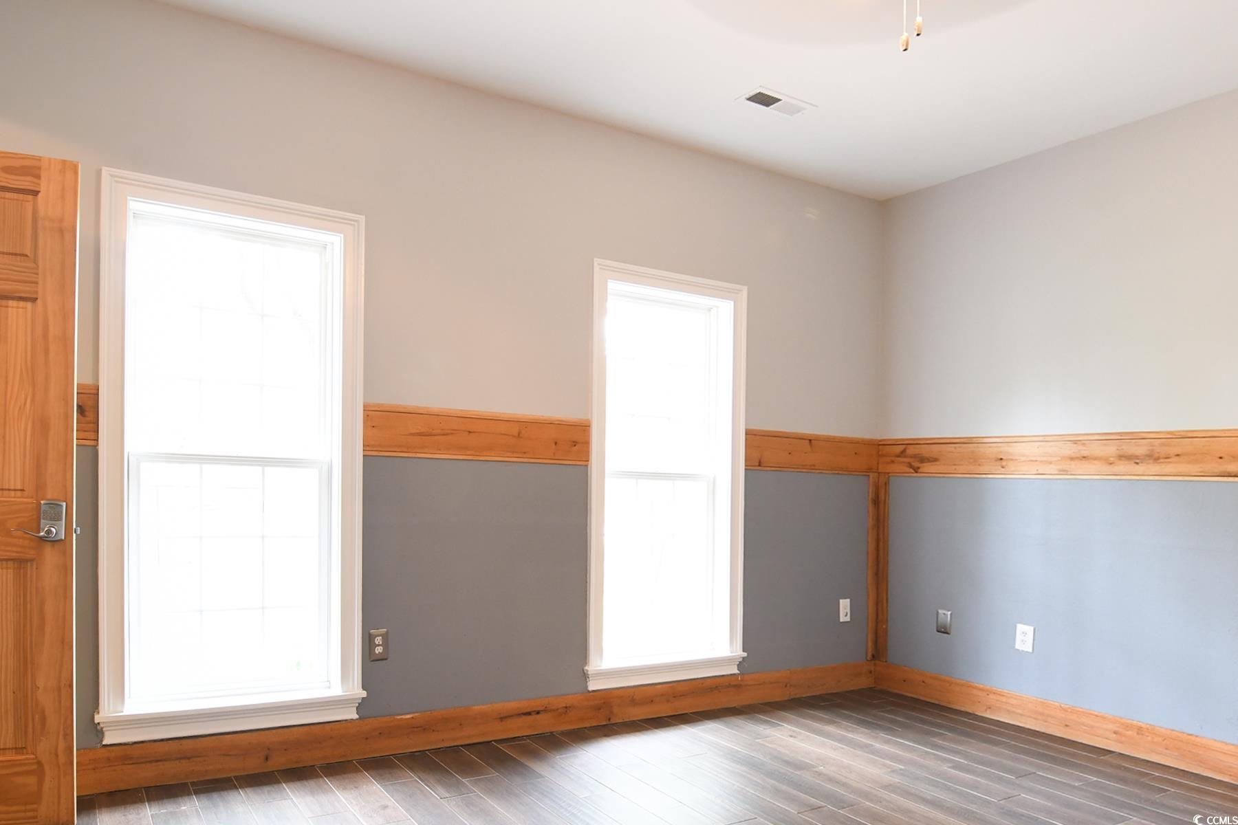 971 Folly Road Myrtle Beach, SC 29588 - Photo 9 of 25 Spare room with wood finished floors, baseboards, and visible vents