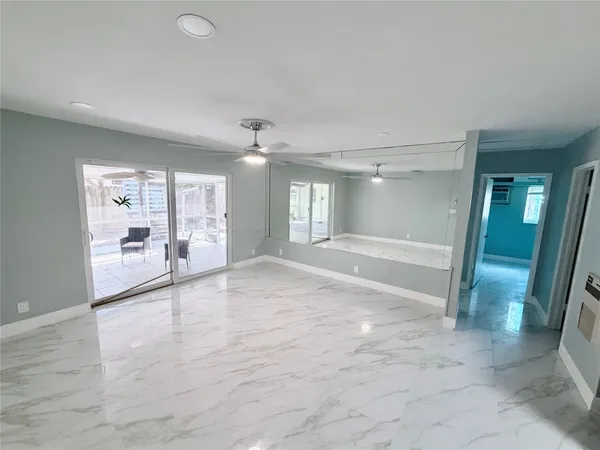 a view of a hallway with wooden floor and a bathroom