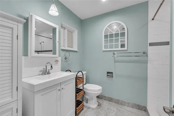 a bathroom with a toilet sink and mirror