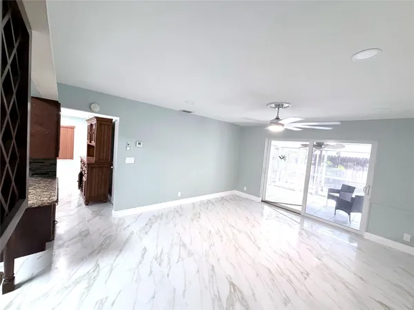 a view of a livingroom with wooden floor and a kitchen space