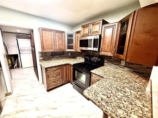 a kitchen with stainless steel appliances granite countertop a stove a sink and a microwave