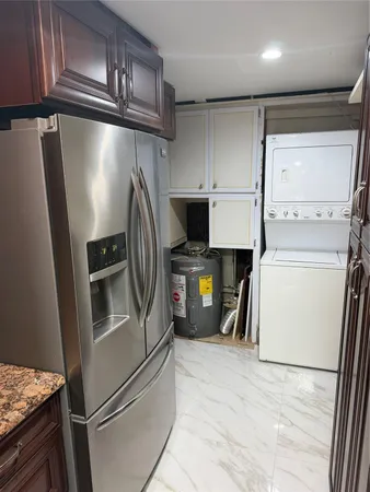 a kitchen with a refrigerator and a stove top oven